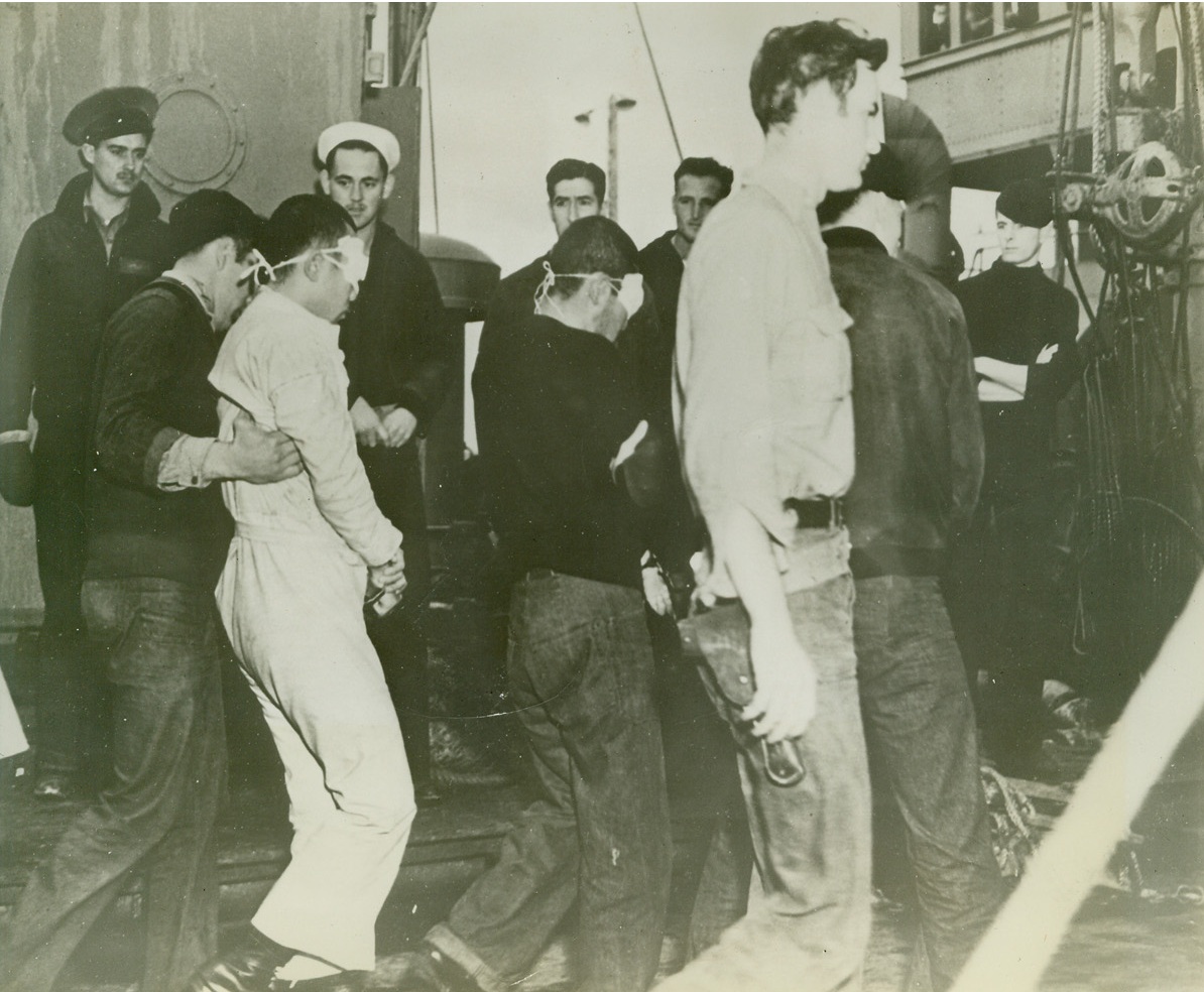 U.S. TAKES JAP PRISONERS IN ALEUTIAN WATERS, 10/7/1942. Blind-folded and heavily guarded, these Japanese arrive at Dutch Harbor, Alaska—but in the role of prisoners rather than fighting men. A naval engagement in Aleutian waters resulted in the capture of these and three other Nipponese. Credit Line (U.S. Navy Official Photo from ACME);