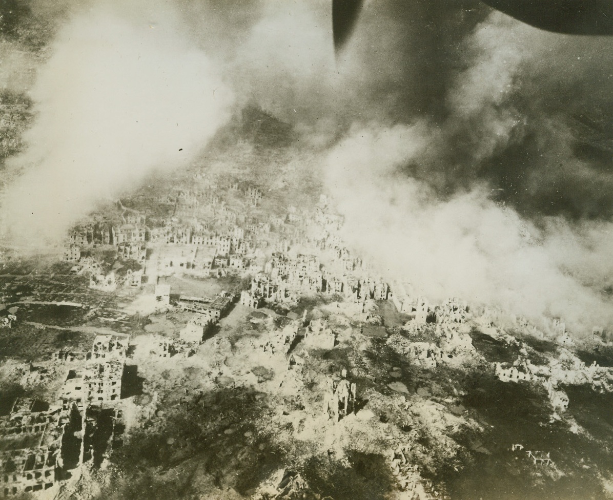 Pall of War Over Cassino, 3/29/1944. ITALY – Taken from a U.S. Army Air Force Reconnaissance plane a few minutes after the last wave of bombers left a record breaking aerial assault on this Italian town, photo gives a close-up view of the devastation left in the bomber wake.Credit (U.S. Army Air Force Photo from Acme);