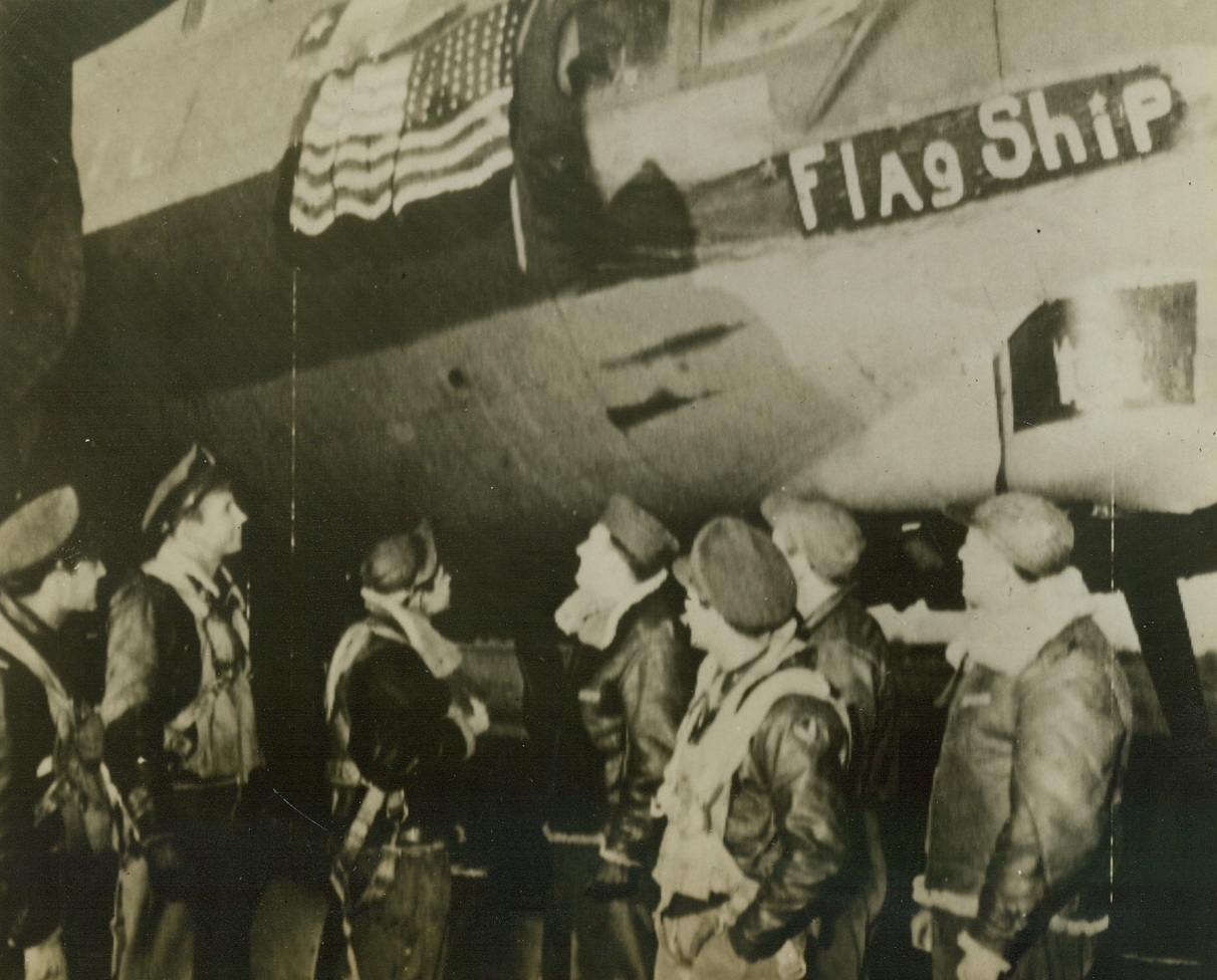 First U.S. Flag Over Berlin, 3/13/1944. Britain – Crew members of the Flying Fortress “Flagship” gaze at the Stars and Stripes painted on the side of their ship after their return to their base “somewhere in Britain,” from the first American daylight raid on Berlin. The flag on the plane’s fuselage was, therefore, the first flag to fly over the German capitol. Left to right are: Lt. William Matetich, of Koppel, Pennsylvania; Lt. Preston M. Dean, Hartsville, South Carolina; T/Sgt. Adolph A. Alvarez, Corpus Christi, Texas; S/Sgt. L.W. Bedey (CQ), of New York City; Lt. A.D. Wolfe, Richmond Hill Long Island, New York; S/Sgt. Thomas Cook, Pittsburgh, Pennsylvania; and S/Sgt. W. Pickup, of Camden, New Jersey. Credit: U.S. Signal Corps Radiotelephoto from ACME;
