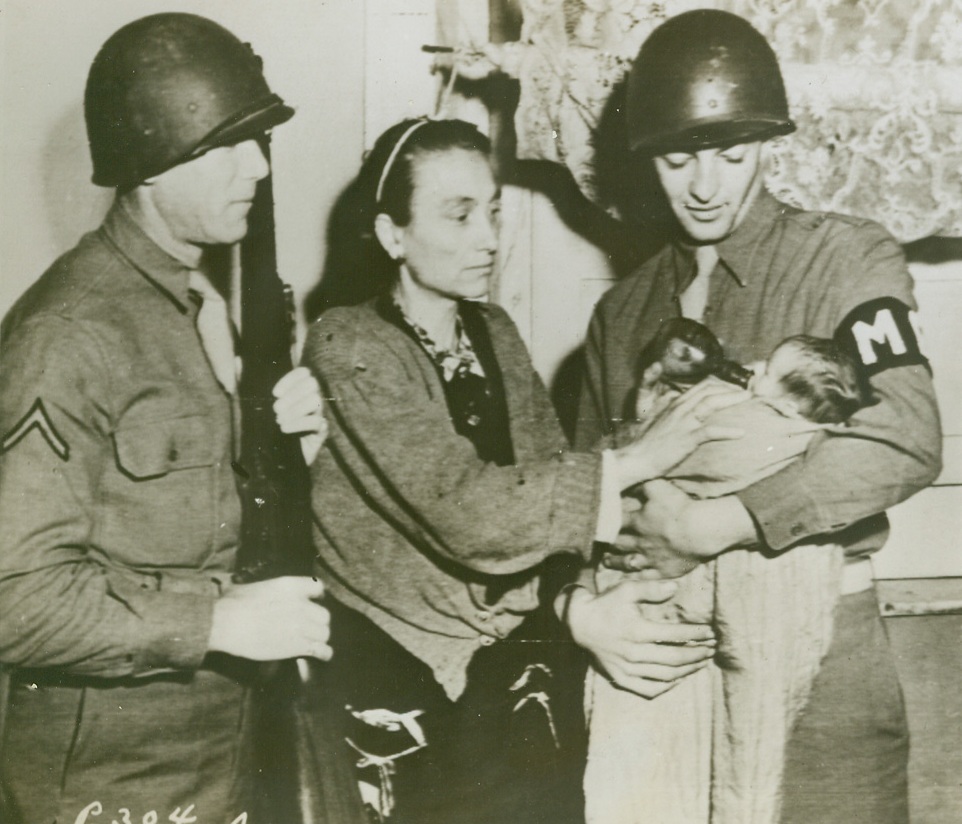 There's Nothing an MP Can't Do, 12/8/1943. ITALY -- Pfc Hyman Huberman, left, and Pfc Sidney Berchofsky, right, both of Brooklyn, N.Y., members of an MP battalion stationed in Italy, look on as this Italian mother feeds the baby they brought into the world in air-raid shelter in Naples. Credit Line (ACME);