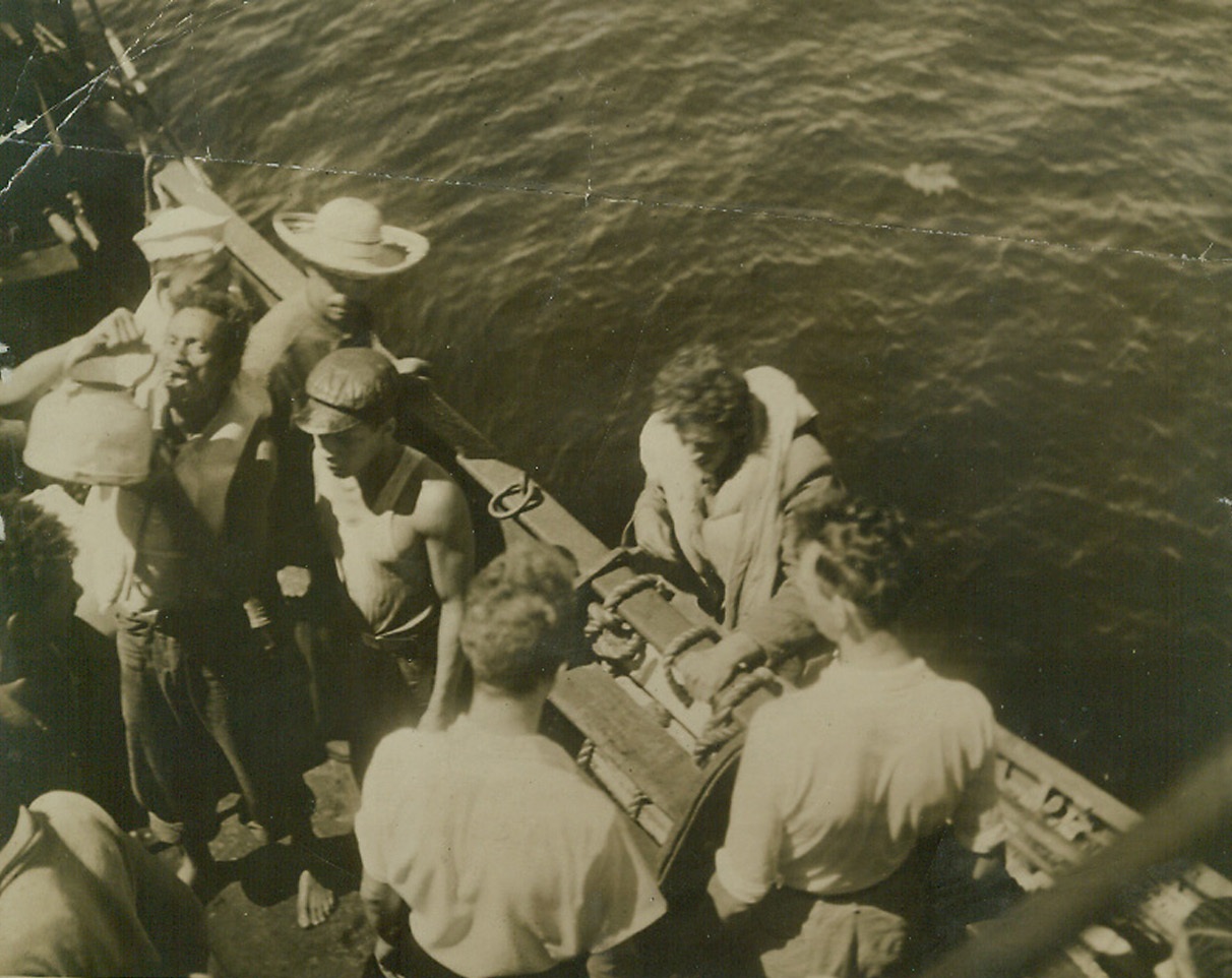 Drifted for 11 Days Before Rescued, 3/23/1942. After eleven days spent in two open boats, 27 survivors (the entire crew) of a small Allied merchantman ship sunk in the South Atlantic March 5, were picked up and all appeared in good shape. A survivor is shown drinking warm water from a tea kettle aboard the rescue ship as another climbs rope ladder. The rescued men said today that their vessel was shelled and machine-gunned for nearly a half-hour by an Axis sub in an obvious attempt to conserve its precious torpedoes. Credit: ACME.;