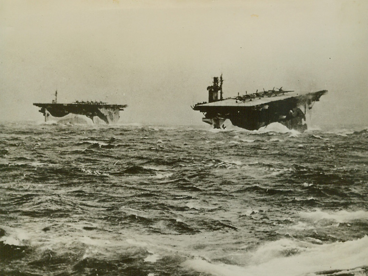Escorts for Allied Convoy, 1/13/1944. At Sea—With fighter planes ranged on their pitching flight decks, the aircraft carriers Avenger and Biter toss in turbulent waters. Escorting an Allied convoy through dangerous waters, the British flattops press on through the stormy weather. Credit: ACME.;