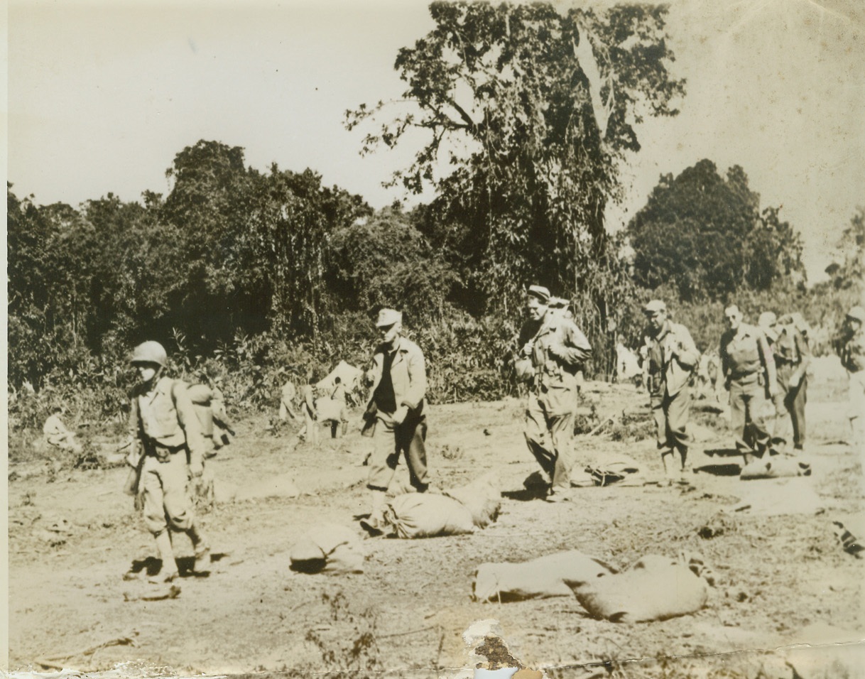BURMA BATTLERS SUPPLIED BY AIR, 3/9/1944. BURMA – Marching over rough terrain to meet the Jap enemy, Lt. Gen. Joseph Stilwell (second in line) and a party of Yanks cross a field littered with supplies dropped by plane in the Hukawng Valley. It is in this Northern Burma territory that “Uncle Joe” was effectively trapped enemy forces, severing all lines of Japanese communication. Credit: ACME;