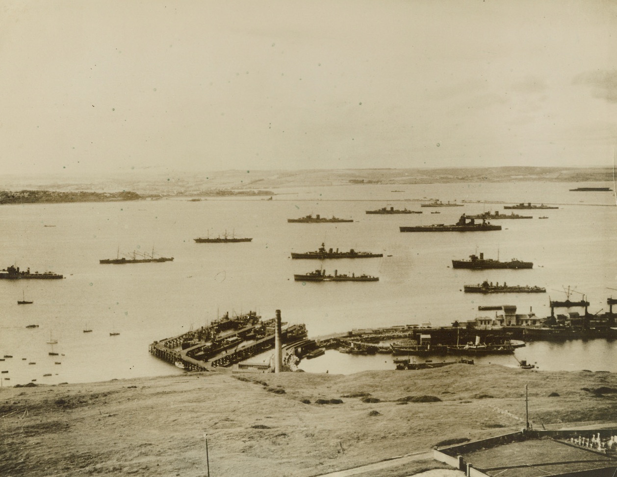Target of Nazi Aerial Blitzkrieg, 8/11/1940  Portland, England – View of the harbor of Portland, England, showing warships anchored in naval drydock (foreground). Portland was the objective of fiercest aerial bombardment of the war on August 11, when wave after wave of Nazi bombers, accompanied by fleets of fighting planes, rained their deadly loads on the harbor works and anchored ships, doing tremendous damage, according to Berlin statement. The attack on Portland was part of the aerial blitzkrieg against other British ports.;