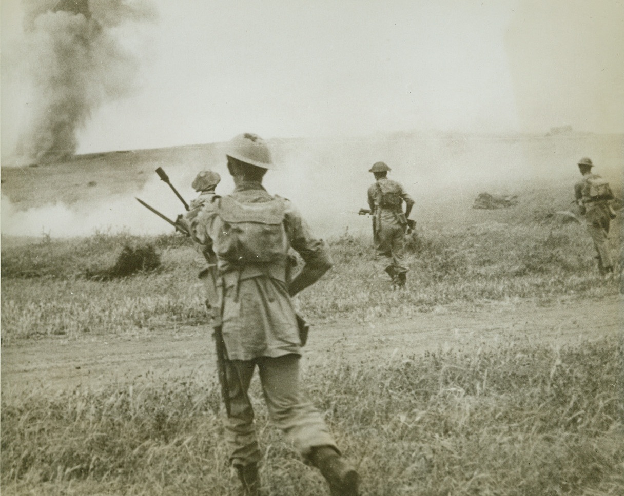 Smashing Through to Tunis, 5/24/1943. Tunisia, N. Africa—The day before the capitulation of Tunis, Eighth Army infantry rush a ridge while under fire from mortars and artillery. After fierce fighting, the British found the fall of the Tunisian capital unexpectedly swift. Credit: ACME.;