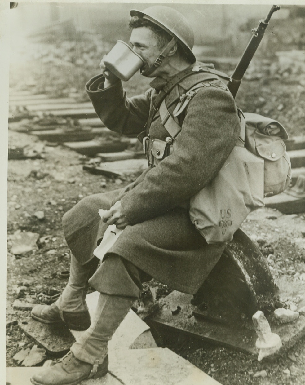 American Soldier Enjoys Mug of Tea in Ireland, 2/8/1942. A NORTHERN IRISH PORT -- An American soldier, member of the American Expeditionary Force, as he enjoyed a mug of tea on a dockside, in "A Northern Irish Port."  Credit: (ACME);
