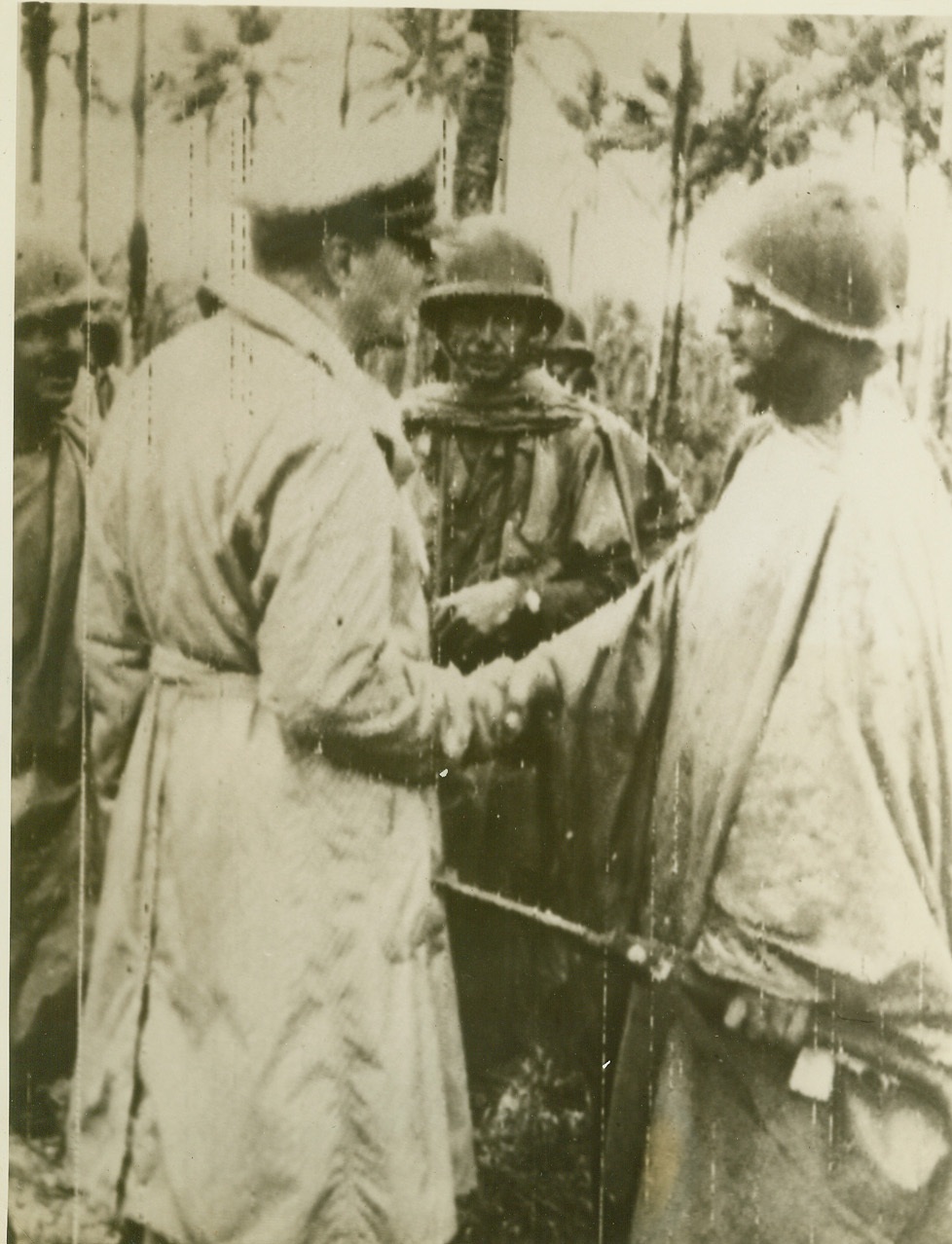 MacArthur Congratulates First Admiralty Lander, 3/2/1944. Los Negros, A.I.—Landing from destroyers Tuesday, Feb. 29th, elements of the U.S. 1st Cavalry Division captured Momote Airdrome on Los Negros Island in the Admiralties. General Douglas Macarthur (L) shakes hands with 1st Lt. Frank Henshaw of Alice, Texas, first man to land on the island, a feat for which he was awarded the D.S.C. Enemy resistance is being rapidly overcome and the operation proved to be extremely successful Macarthur said the action was started as a reconnaissance in force and became an invasion when the opportunity made itself available. Credit: Signal Corps radiotelephoto from ACME;