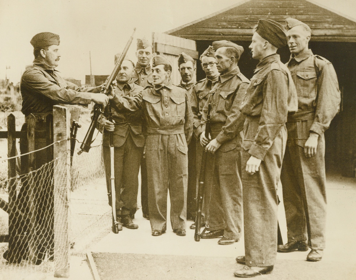 BRITAINS GETTING READY FOR PARACHUTISTS, 5/29/1940  ENGLAND—An Army sergeant of the last war handing out rifles in eastern England to Local Defense Volunteers before their first tour of duty. Some 250,000 of these Local Defense Volunteers are ready in Britain to repel invading parachute troops. Credit Line(ACME);