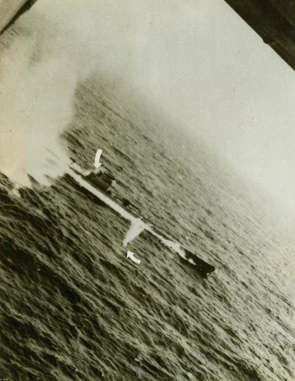 ”Tidewater Tillie” Scores Again – (#1), 5/25/1943. The crew of a specially equipped Liberator B-24 Bomber of the U.S. Army Air Forces Anti-Submarine Command made this photo of a successful attack on a Nazi U-Boat, proving they had scored a “kill”. Once before they had attacked an enemy sub and had been given credit for only a “Probable”, because their photos hadn’t shown conclusively that the undersea boat was destroyed. This time, photos of the attack, and of the wreckage on the surface after the attack made the “kill” a certainty. Here, the B-24 comes in on its bomb run over the sub, its machine guns blazing. Arrow, (at left), shows a Nazi crew member hit and dropping to the deck, after an American bullet had scored a hit. Another machine gun bullet splashes into the sea, (arrow at right). A few seconds later, depth bombs from the plane blasted the sub to the bottom.  Credit line (U.S. Army Air Forces Photo);