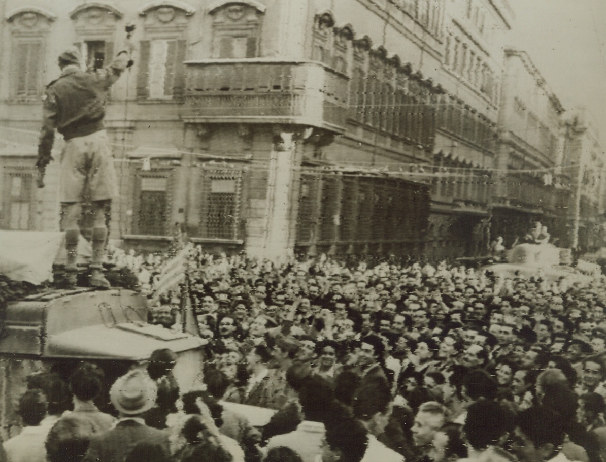Jubilant Romans Cheer Allies, 6/5/1944. ROME—Wildly cheering throngs, gathered in Mussolini Square to celebrate the fall of Rome to the Allies, swarm around a sound truck (in foreground), while an Allied tank is hemmed in by crowds in background. The city was in a carnival mood as victorious Allied troops entered. Credit:  SIGNAL CORPS RADIOTELEPHOTO FROM ACME.;