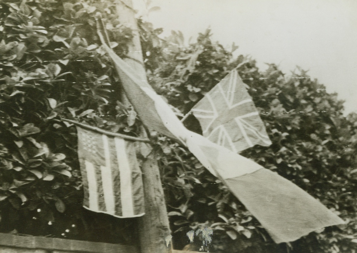 It’s The Spirit That Counts!, 6/22/1944. Trevieres, France - The natives in the Norman village of Trevieres, made these American, French and British (left to right) flags to honor the Allied troops of liberation marching into their town. Although the banners are crudely put together (the U.S. flag lacks the proper number of stars and stripes), it was the spirit of the gesture that pleased the Allied liberators. Credit: Army Radiotelephoto from ACME;