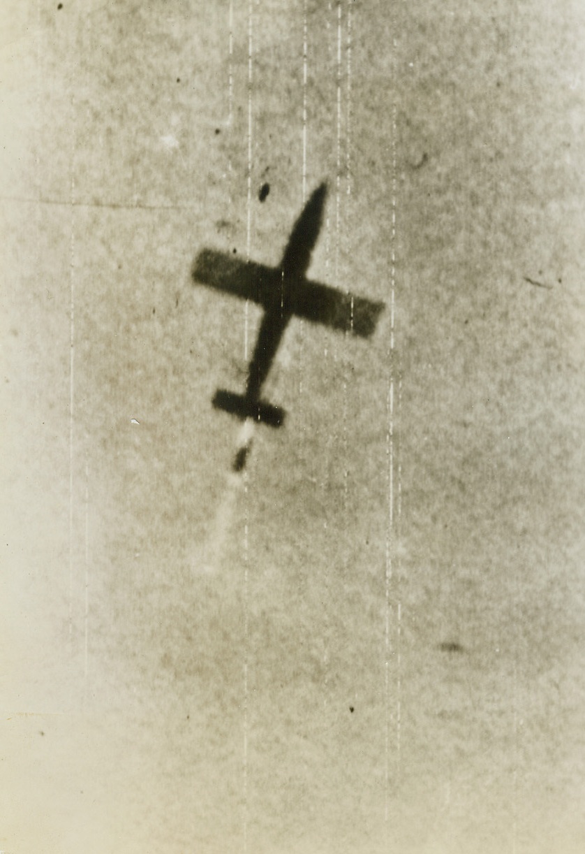 Pilotless Plane Zooms Down, 6/19/1944. Southern England -- Diving to earth for its vicious attack, a German pilotless plane zooms through Southern England skies with flame streaming from the propulsion unit (mounted above and behind tail). The mystery plane has a 16-foot wingspan and is 25 ft., 4 1/2 inches long. It was disclosed today that six months of ceaseless air attack has knocked out so many of these platforms used to launch these robot planes that the pilotless bombs, when they were finally loosed, went out on less than one-fourth the scale the Nazis wanted. Credit: ACME photo via U.S. Signal Corps Radiotelephoto;