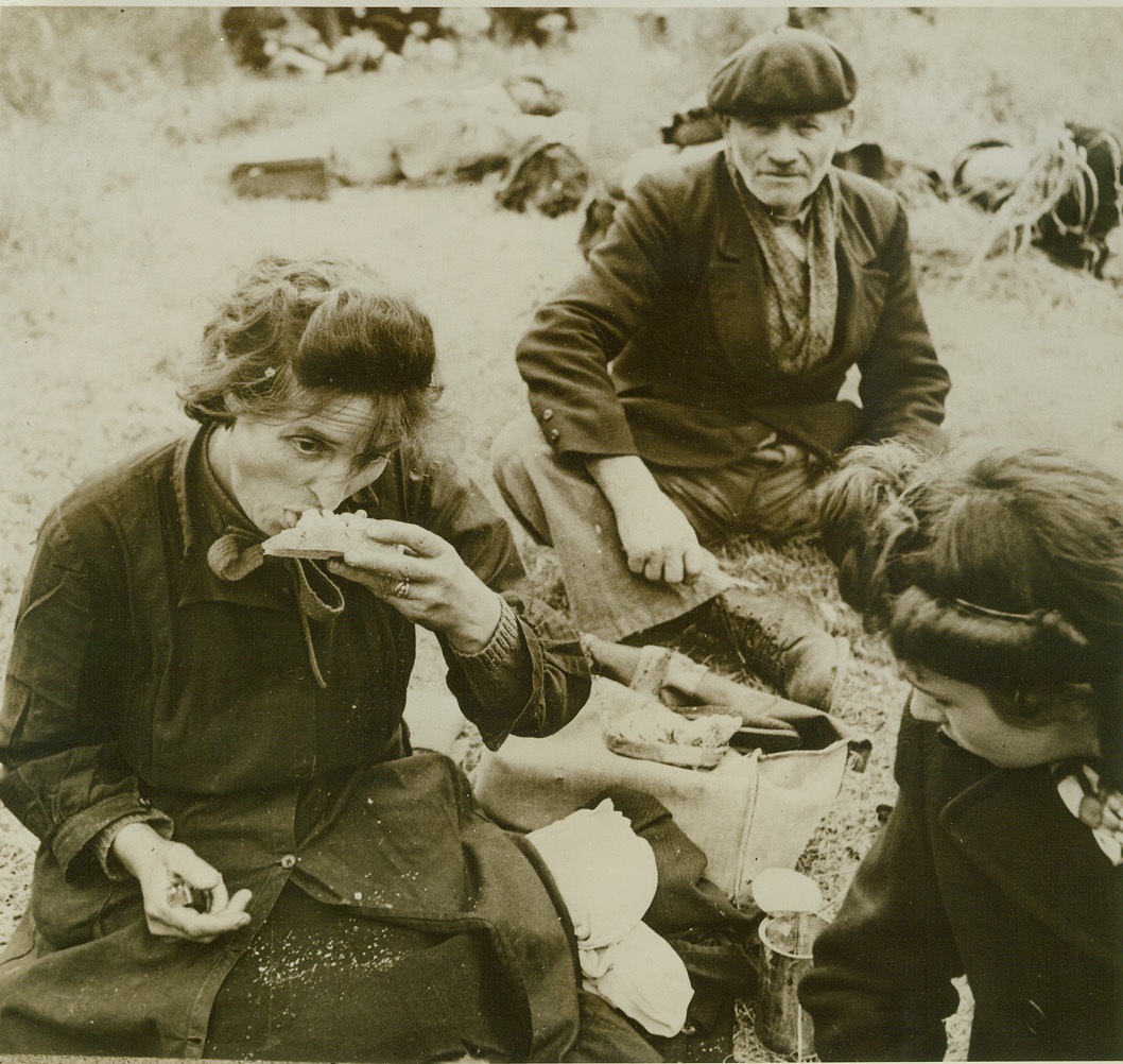 They Eat in Peace, Now, 6/15/1944. France—Eating for the first time in many days, these French refugees sample U.S. Army food supplied through the civil affairs department. The fact that they are free from the Nazi yoke makes their meal double tasty.  Credit: British official photo from ACME;